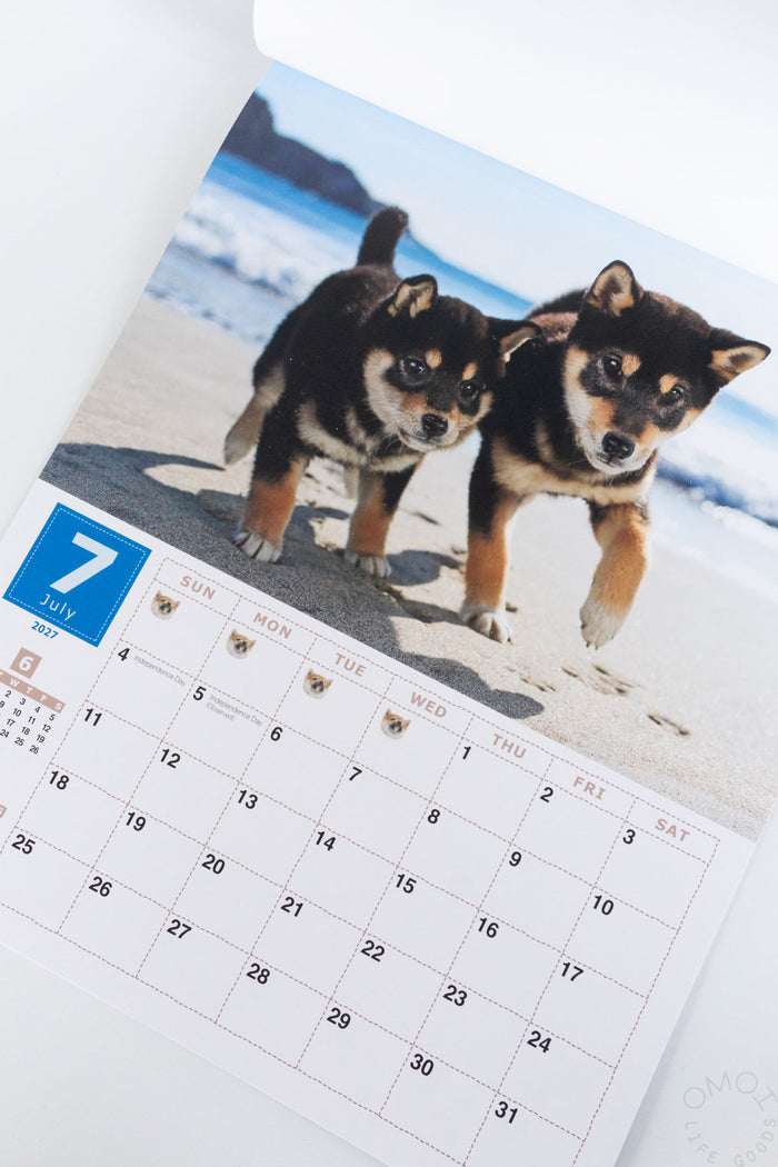 Shiba Inu wall calendar page showing two Shiba Inu dogs on a beach