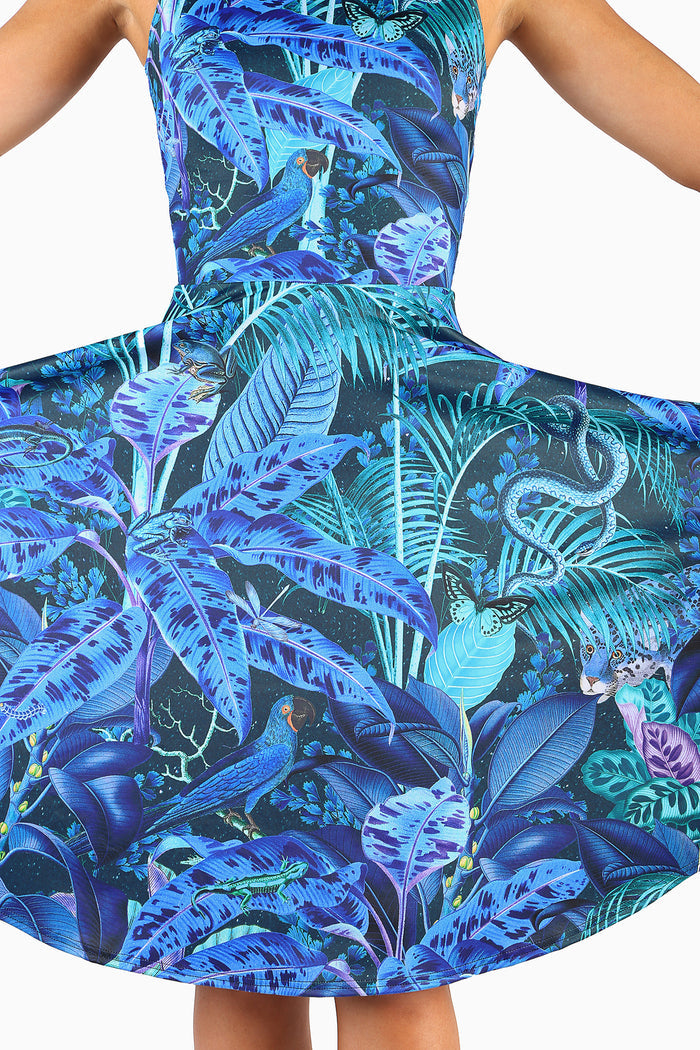 Dress with a blue and green jungle print featuring birds and foliage on a white background