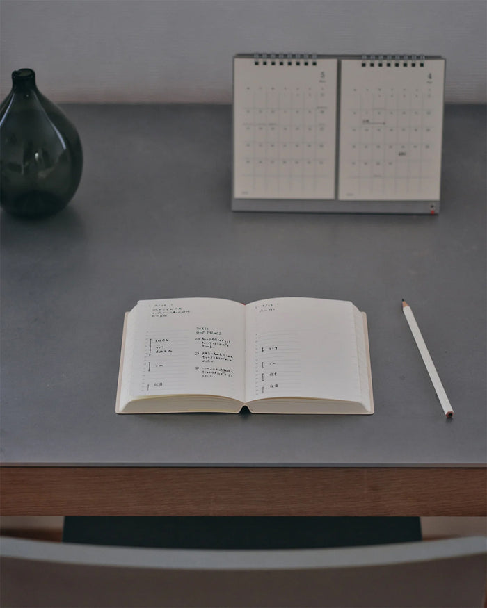 Open page-a-day planner on tabletop with day pages and handwritten text