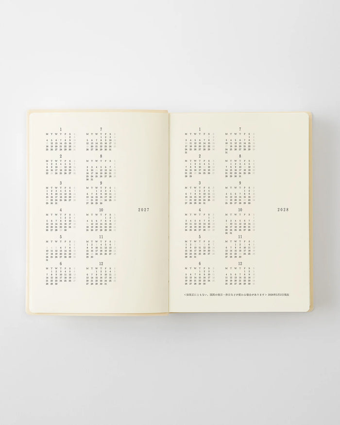 Open page-a-day planner showing monthly calendar grid spreads