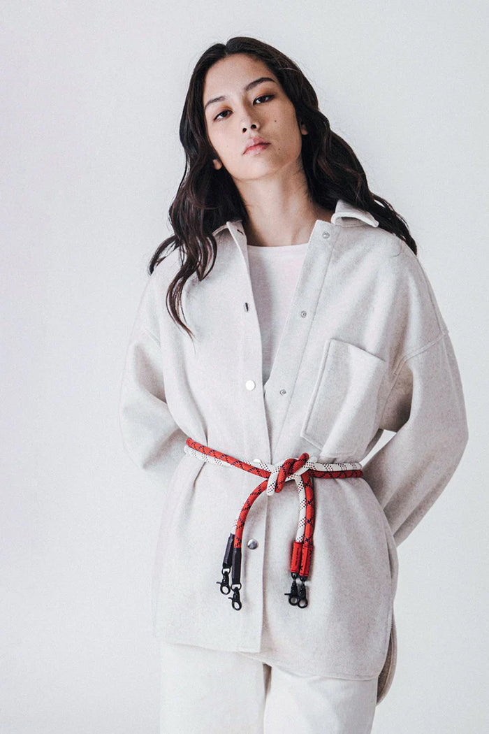 Light rope strap with red ends and metal clips on a crossbody bag